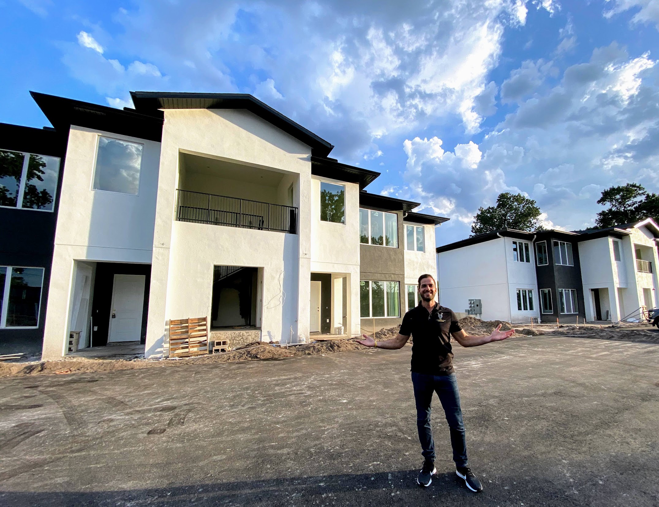 Christopher in front of luxury custom home nearing completion